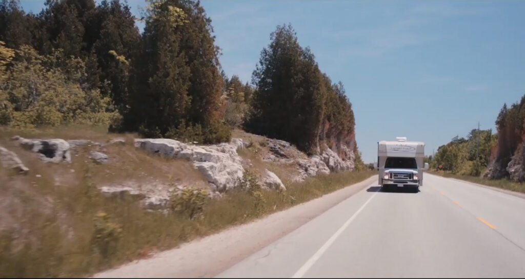 Still from corporate video featuring an RV on an open road